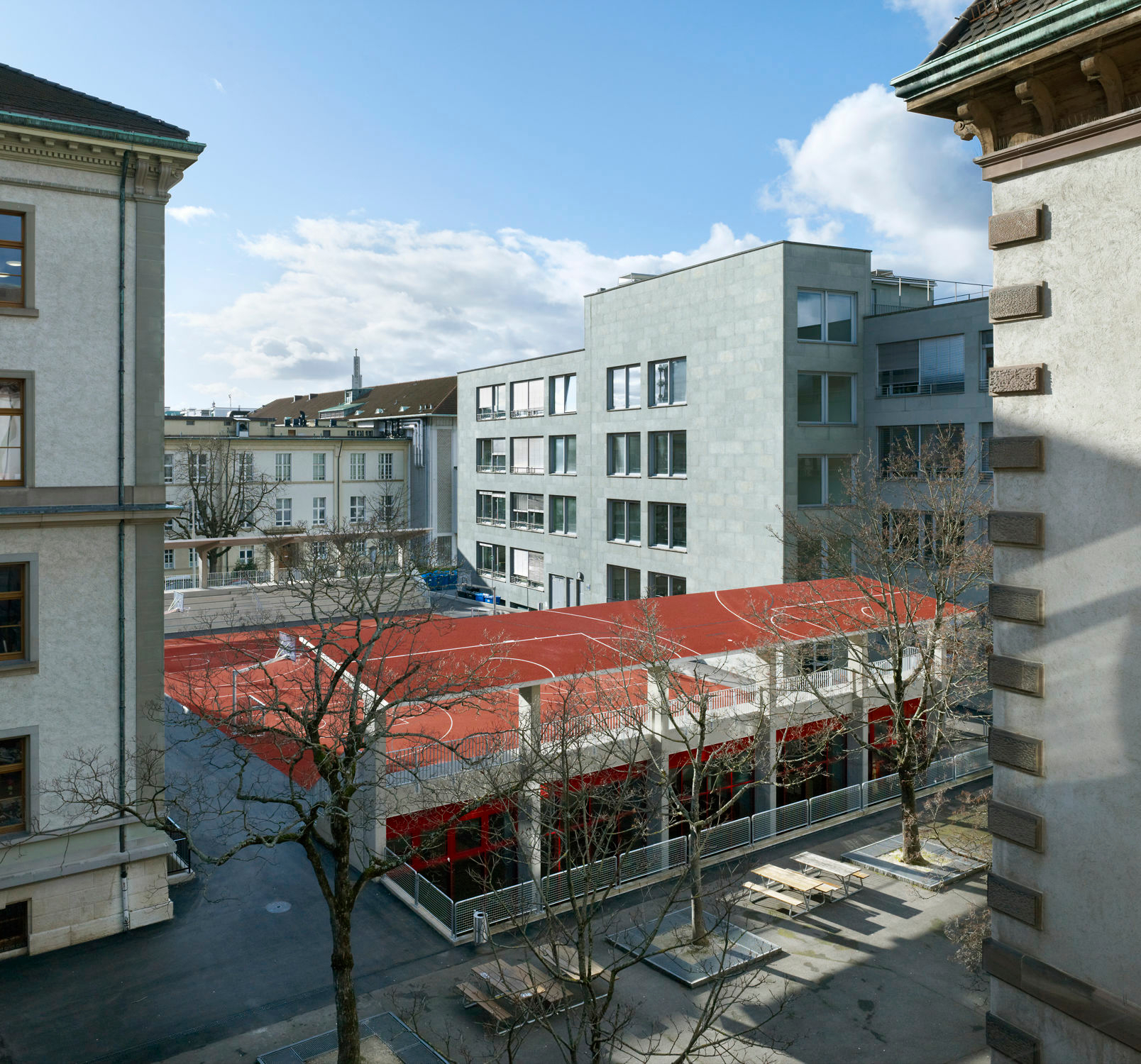 Unter dem Platz liegt eine kombinierte Schwimm- und Sporthalle mit zwei seitlich eingeschnittenen Lichthöfen.