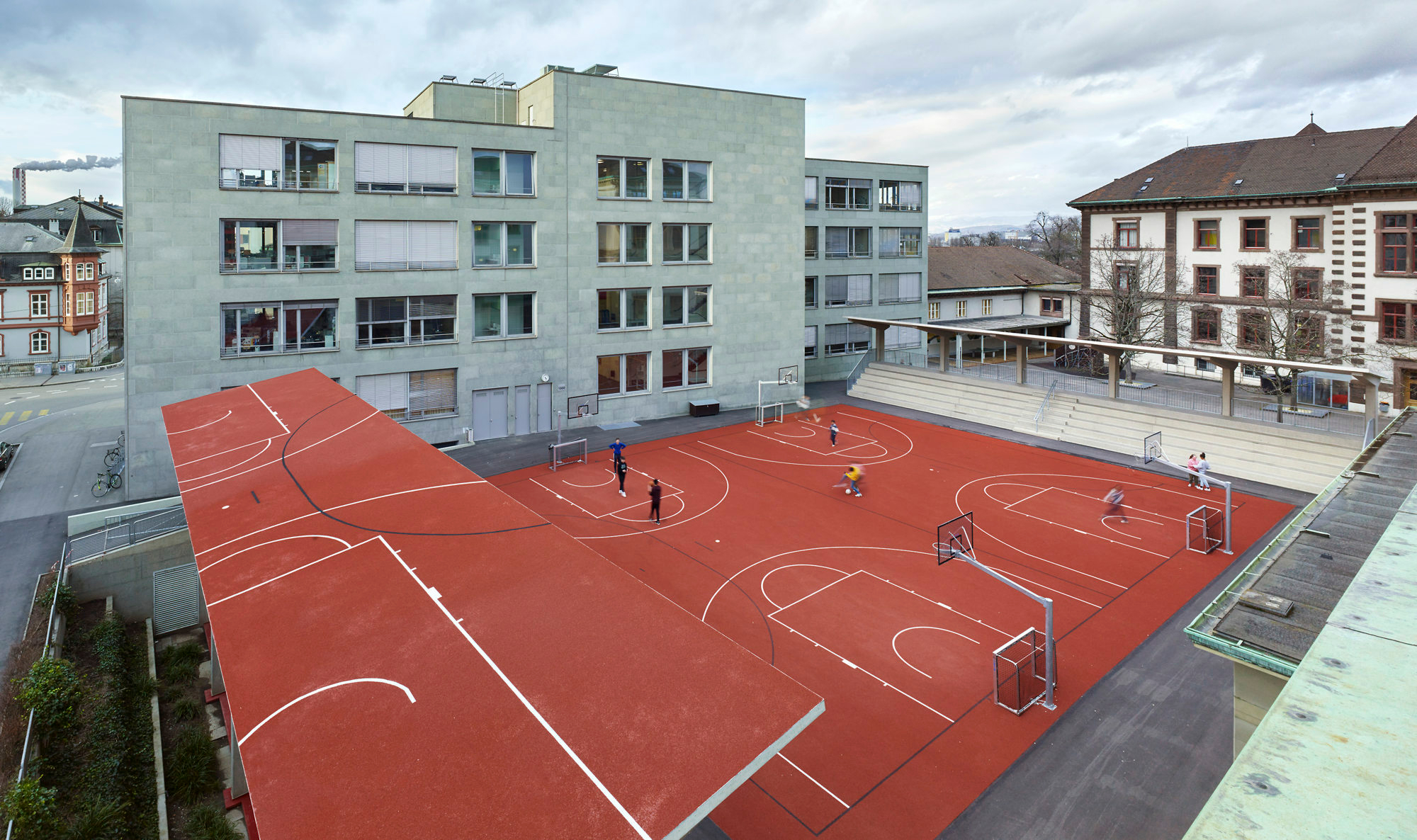 Die auffällige Platz- und Dachgestaltung ist von den umliegenden Schulräumen aus einsehbar. Im Hintergrund zu sehen ist das Vogesen-Schulhaus.