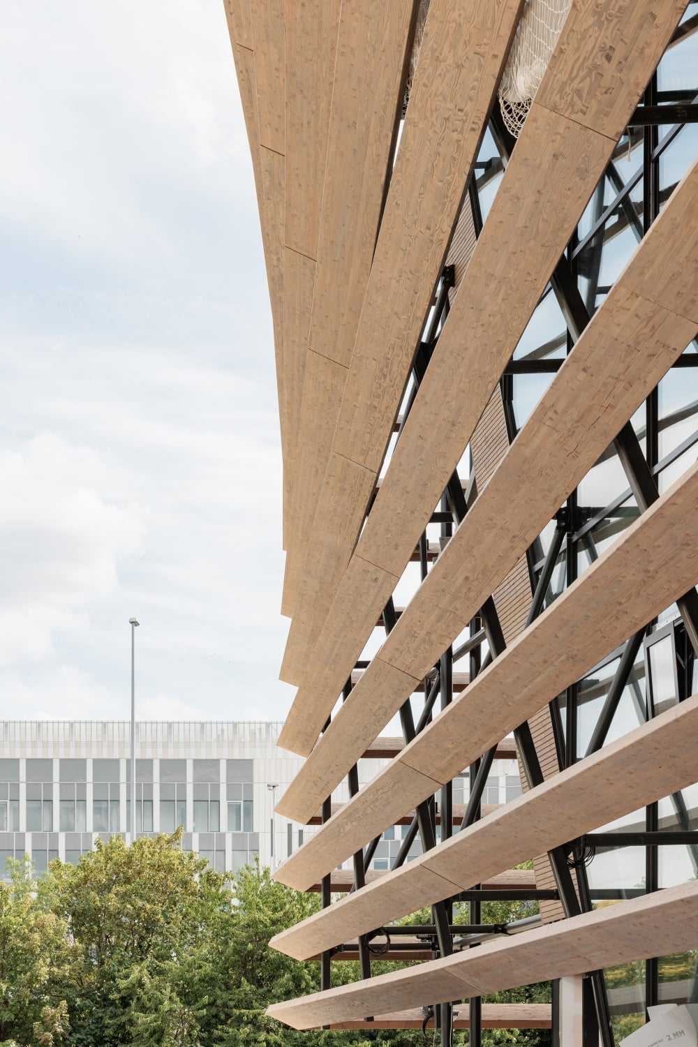 Die äußere Fassadenschicht aus Holz wird von einer filigranen Konstruktion aus Stahl getragen.
