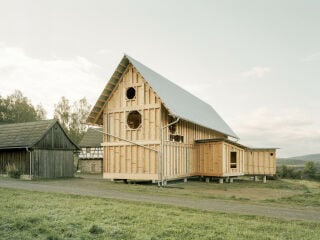 Die dem Hof zugewandte Eingangsseite ist durch gleichmäßige Reihen bodentiefer Fenster bestimmt.