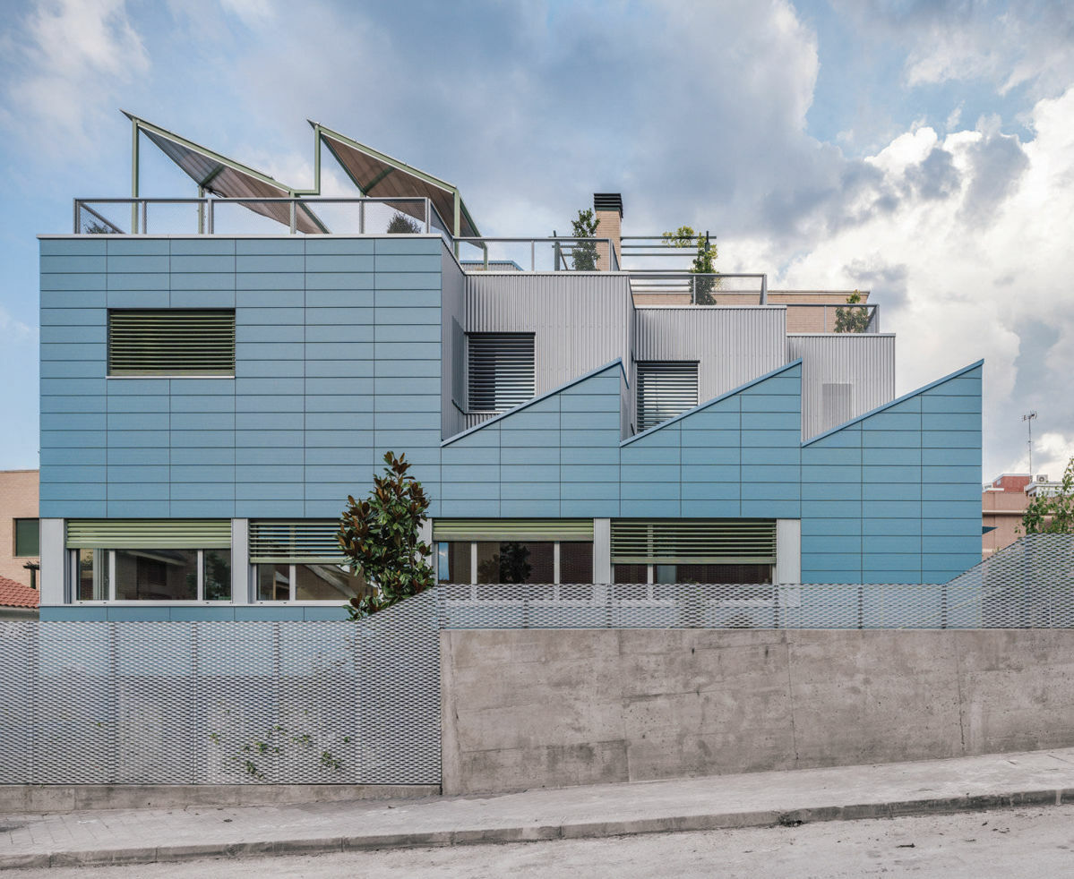 Mit seinem Sheddach und der himmelblauen Fliesenfassade sticht das Beyond the Family Kin Housing architektonisch aus der b&uuml;rgerlichen Wohngegend hervor. 