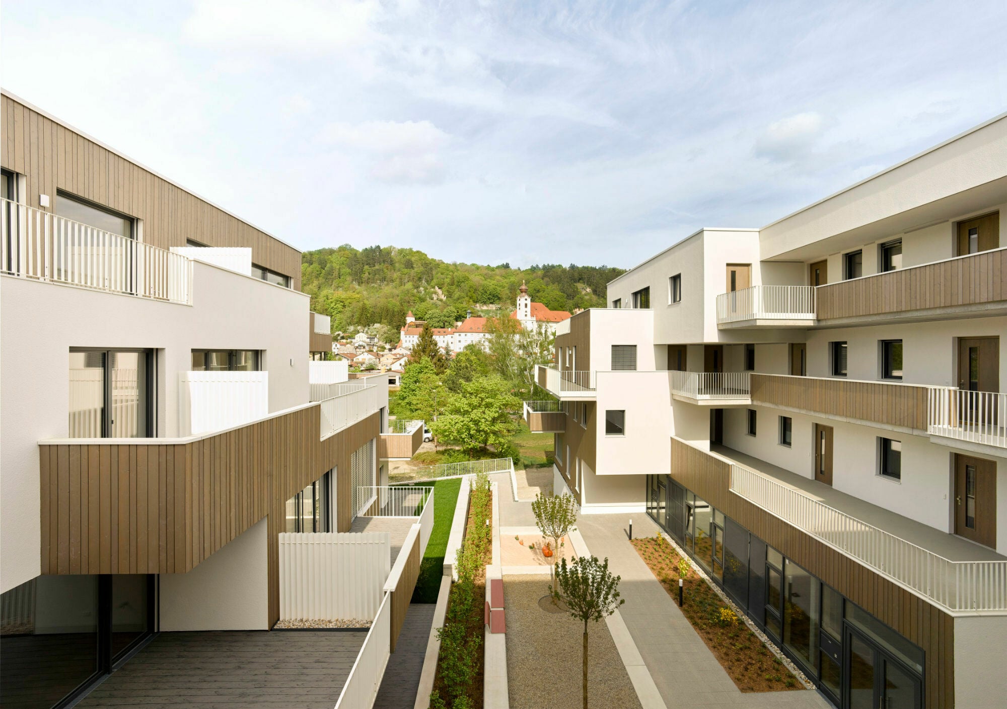 Zwischen den beiden Baukörpern lädt ein gemeinschaftlich genutzter, begrünter Innenhof zum Verweilen ein.