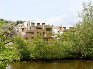 Am Ufer der Altmühl im bayerischen Eichstätt hat das Stuttgarter Planungsbüro Behnisch Architekten ein terrassiertes Wohn- und Geschäftshaus realisiert.