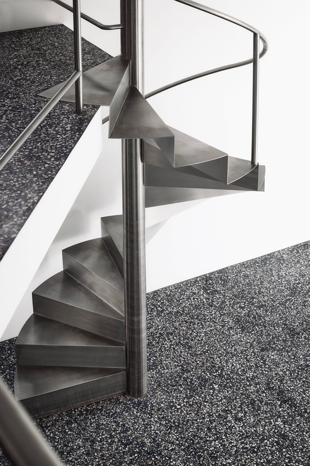 Eine Spiendeltreppe aus Edelstahl führt im sechs Meter hohen Wohnraum vom Erd- ins  Zwischengeschoss.
