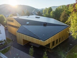 Die Dachflächen der neuen Gemeindehalle in Arlesheim sind mit den Solarziegeln des Herstellers SunStyle gedeckt, die Strom für vierzig Haushalte generieren.