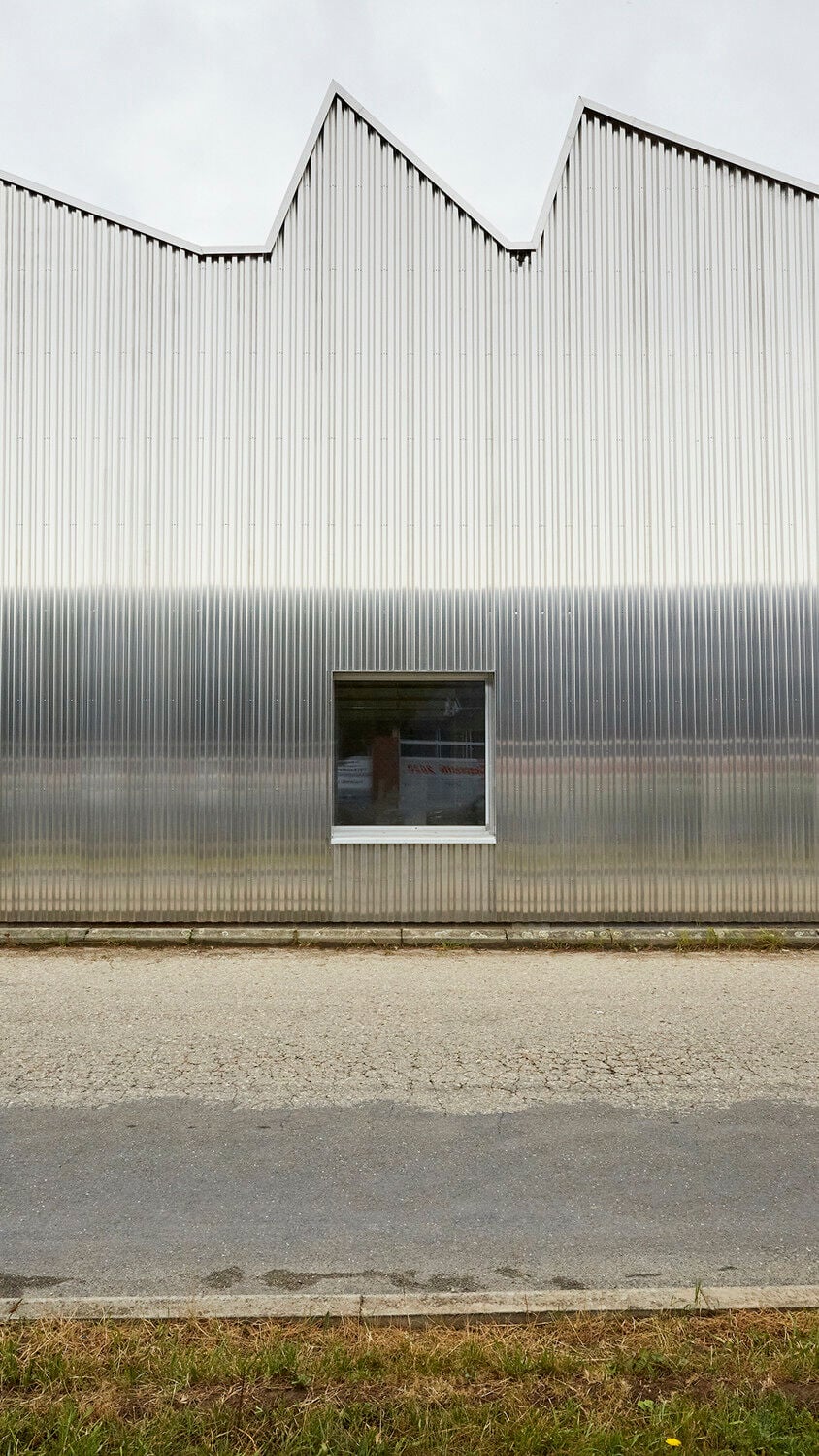 Eine vorgehängte Metallfassade gibt Bestand und Anbau ein einheitliches Äußeres.
