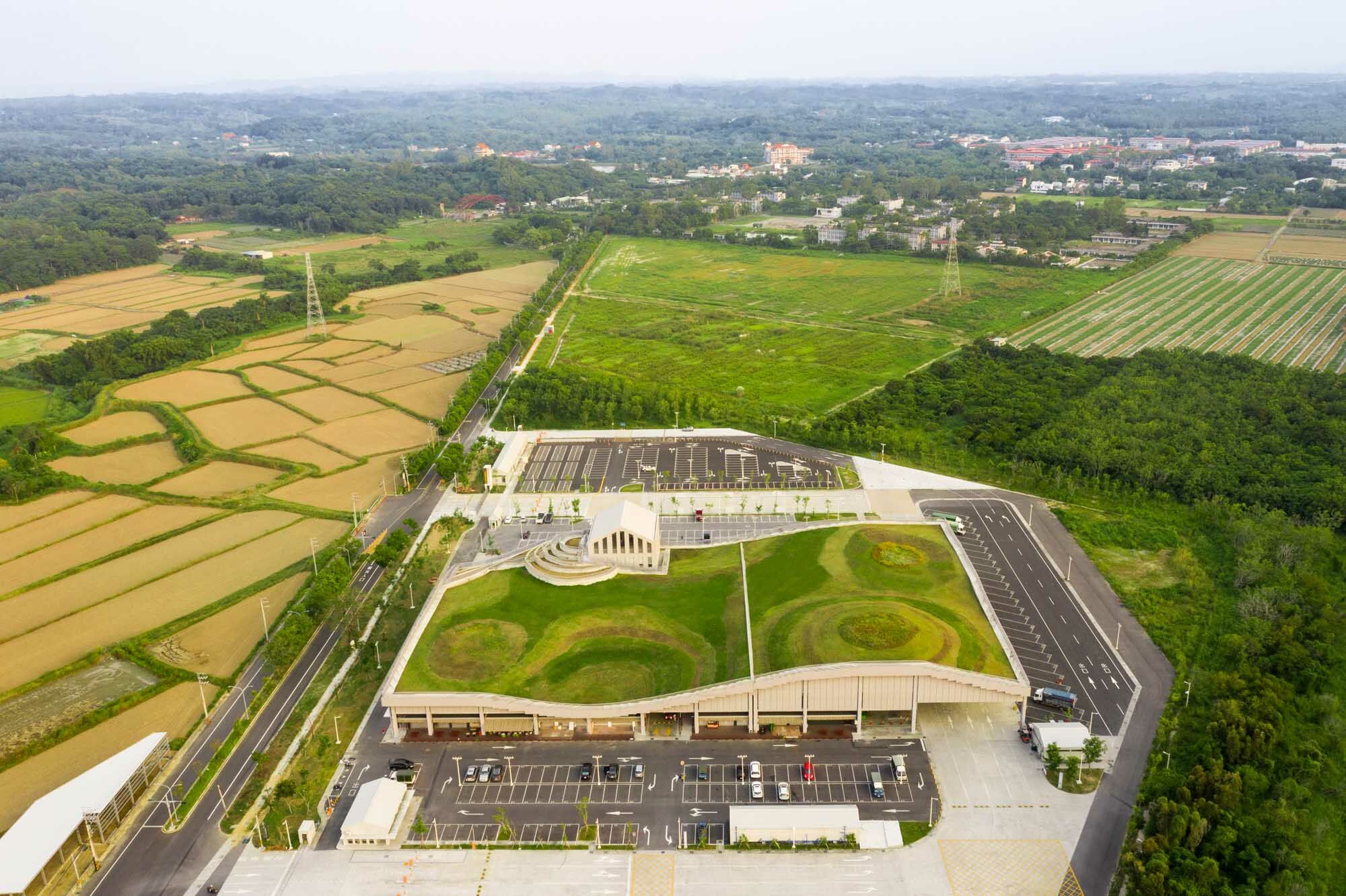 Die über 12.000 Quadratmeter umfassende Anlage mit einem wellenförmigen, begrünten Dach entstand in der leicht hügeligen Landschaft östlich von Tainan.