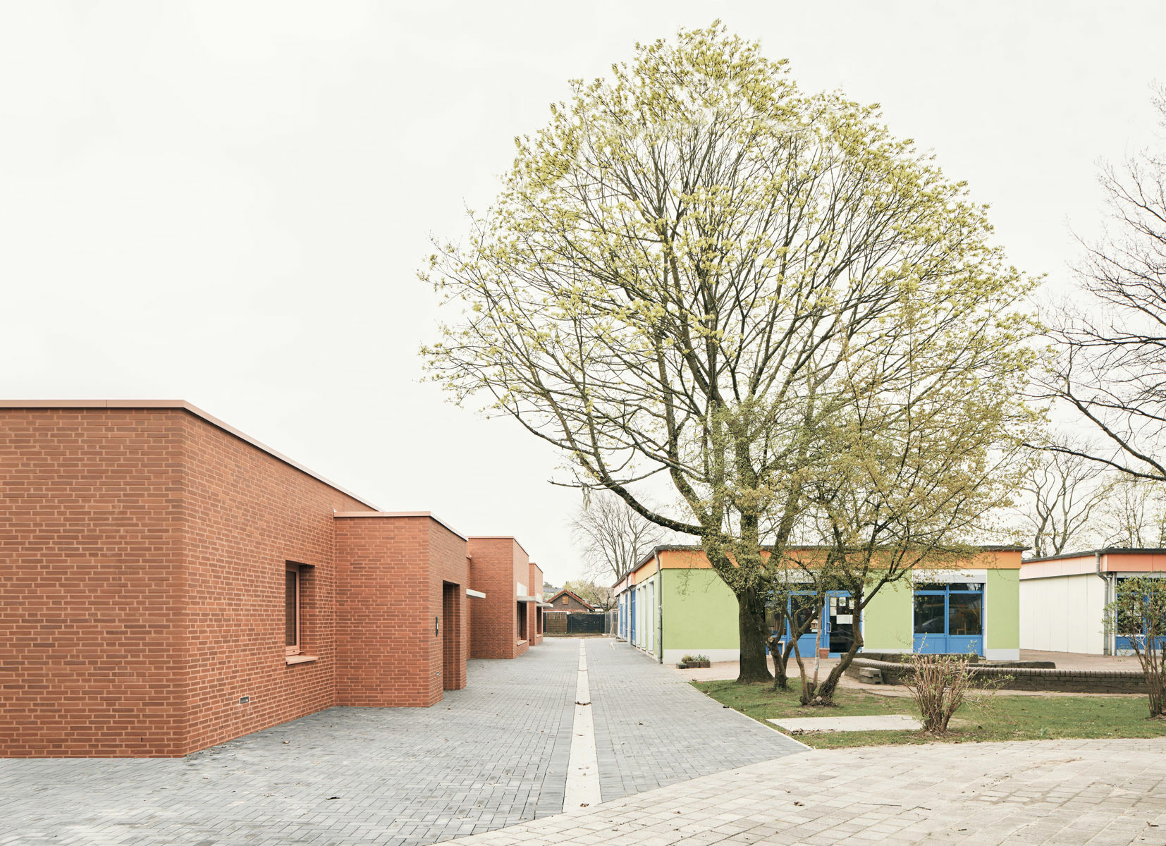 Die vorspringenden Kuben sorgen für Bewegung auf der Südseite des langgestreckten Gebäudes. Der Raum zwischen den Baukörpern dient als Spielgasse.