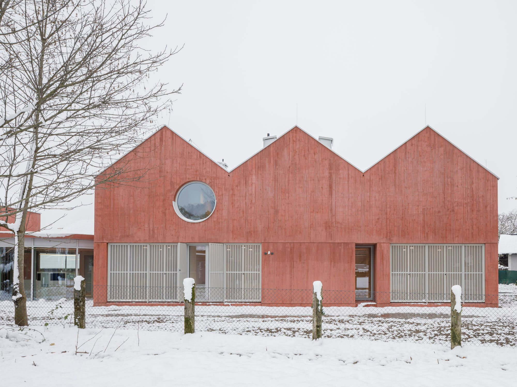 In Anif, im Umland von Salzburg, eröffnete 2023 eine kleine Klinik, deren rote Sichtbetonhäuser von Steiner Architecture geplant worden waren.