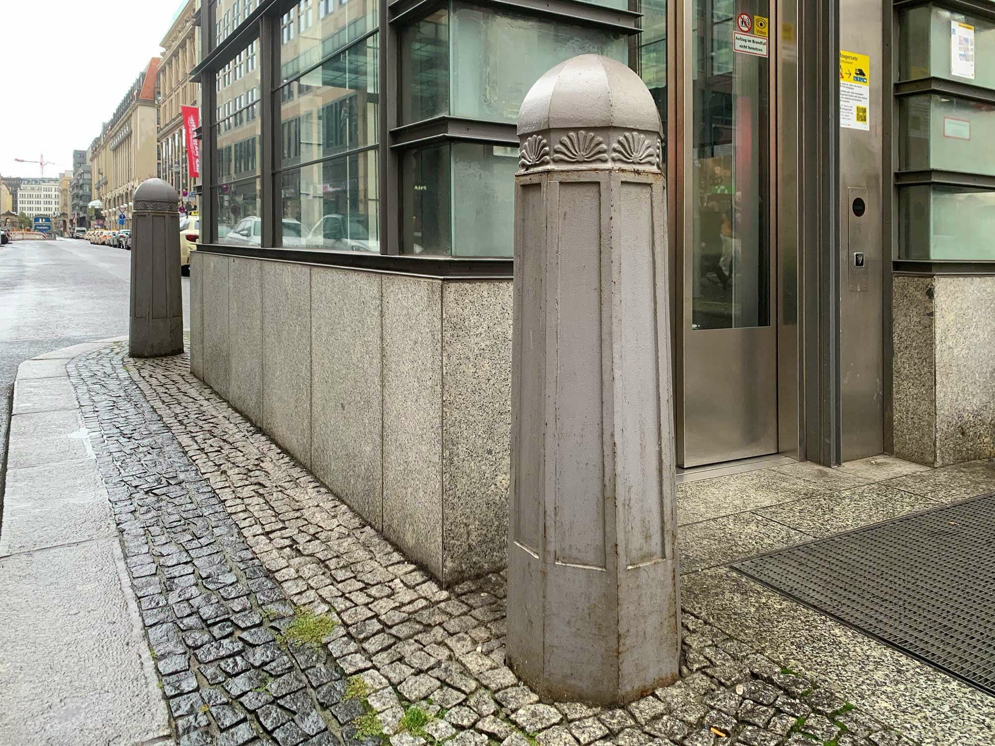 Poller sind im Amtsdeutsch Sperrpfosten. Im Bild: Ein Poller als Kontroll- und Zugangssperre vor dem Eingang in ein Bürogebäude.