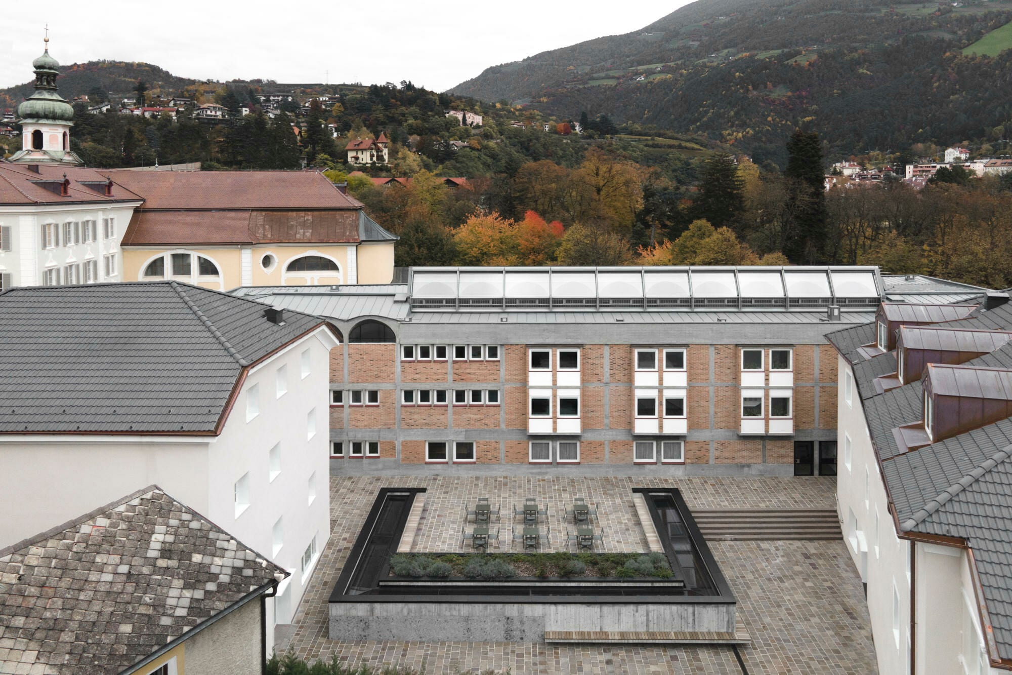 Ein u-förmiges Oberlicht deutet den neuen, unterirdischen Konferenzsaal an. Die Nikolaus Cusanus Akademie in Brixen erhielt eine Anerkennung.