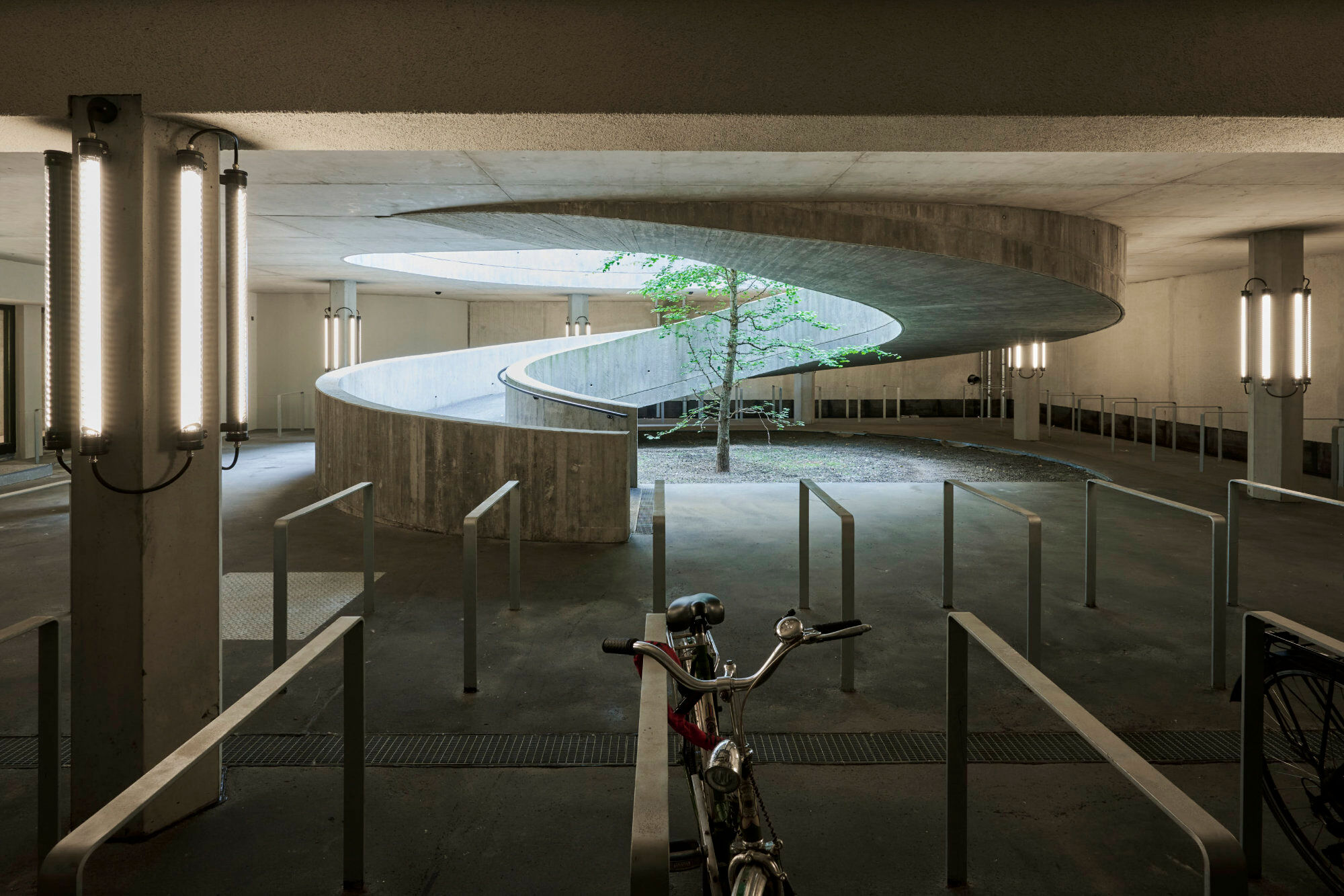 Die Betonrampe führt in das Untergeschoss, in dem ein Fahrradkeller mit 100 Stellplätzen untergebracht ist.
