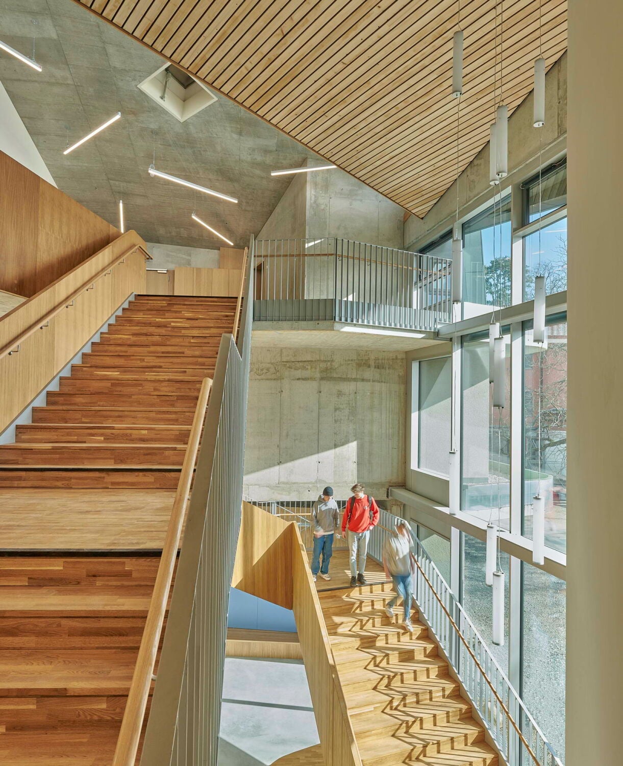 Das Herz des Neubaus ist das große, zentrale Atrium, in dem alle Wege zusammenführen und das sich über eine fast gebäudehohe transparente Fassade zum Pausenhof öffnet.