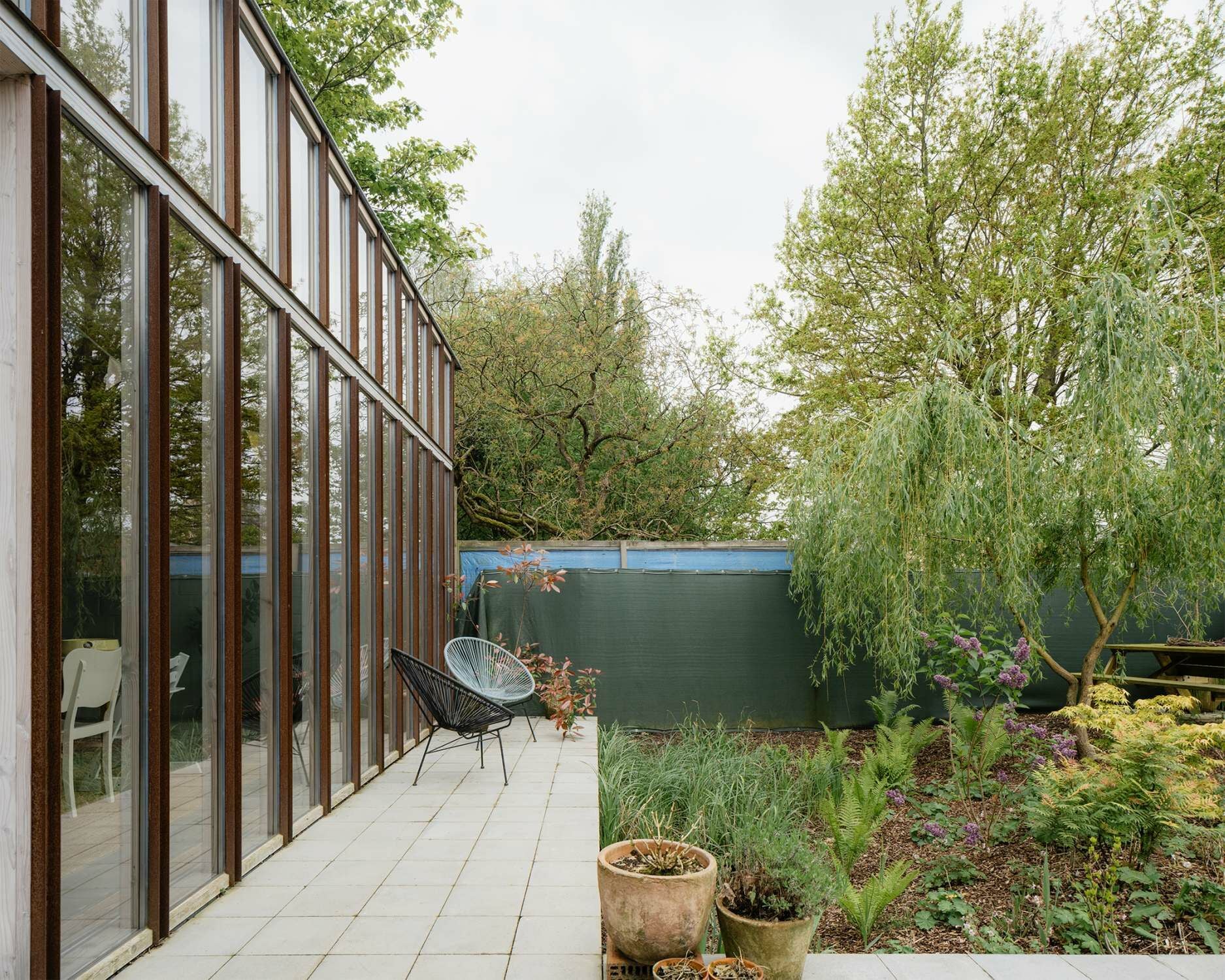 Das Gartenhaus öffnet sich über eine verglaste Fassade zum privaten Garten hin...