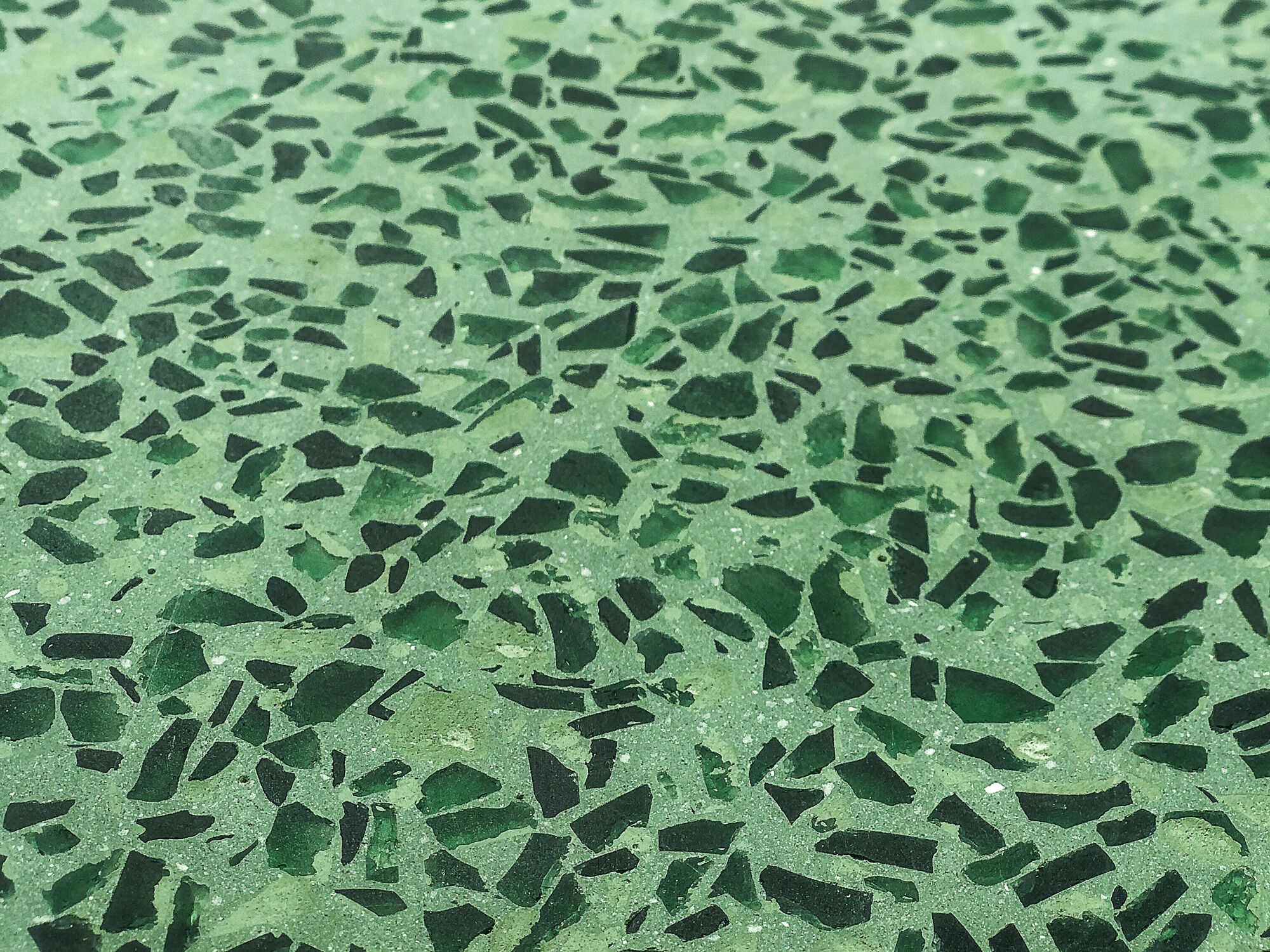 Das deutsche Unternehmen VIA stellt einen fugenlosen Terrazzo aus Bauabfällen her, der zement- und epoxidharzfrei ist. Im Bild: Terrazzo aus recycelten grünen Glasflaschen