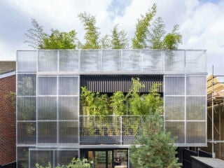 Das Green House liegt zwischen zweistöckigen Ziegelhäusern mit Steildächern aus den 2000er Jahren.