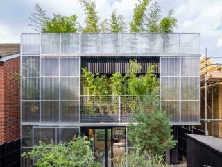 Das Green House liegt zwischen zweistöckigen Ziegelhäusern mit Steildächern aus den 2000er Jahren.