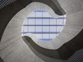 Regelmäßig angeordnete Fassadenstützen aus Beton prägen die Hülle des Primarschulhaus Vinci in Suhr von pool architekten aus Zürich