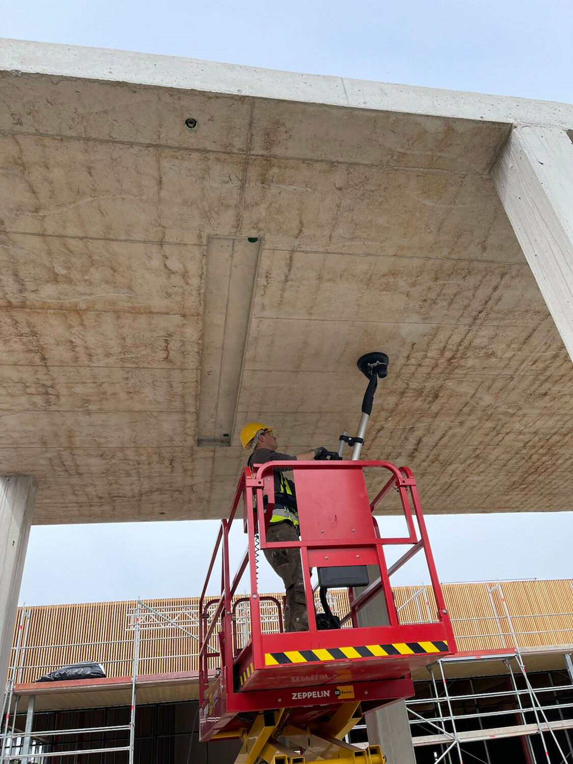 Betonkosmetiker*innen bearbeiten mitunter schwer zugängliche Flächen, wie bei dieser Über-Kopf-Reinigung.