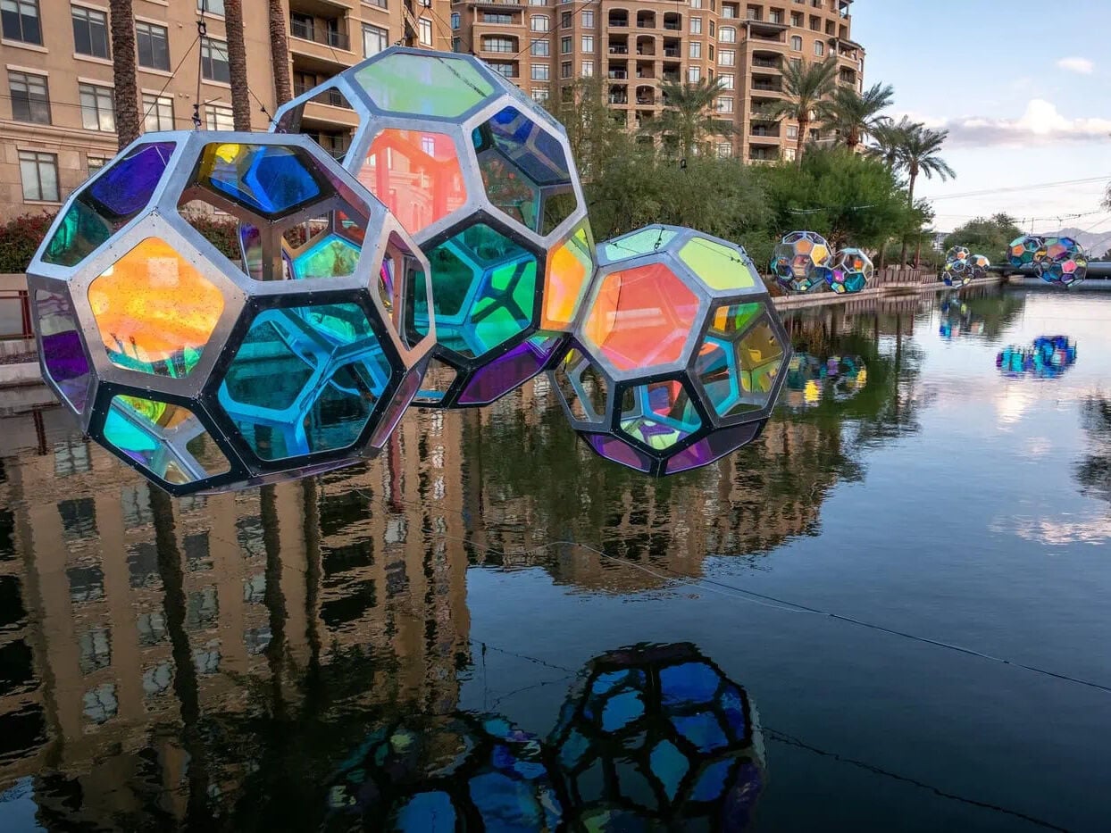 Reflexionen von Molekülen am Arizona-Kanal mit der McDowell Mountain Range im Hintergrund. 