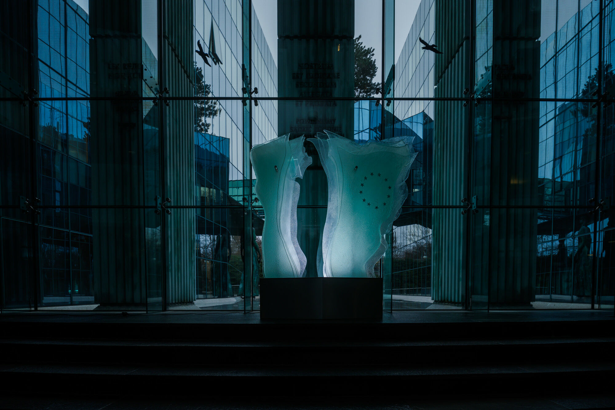 Tagsüber bricht die Skulptur das Tageslicht, nachts leuchtet sie aus dem Sockel heraus.