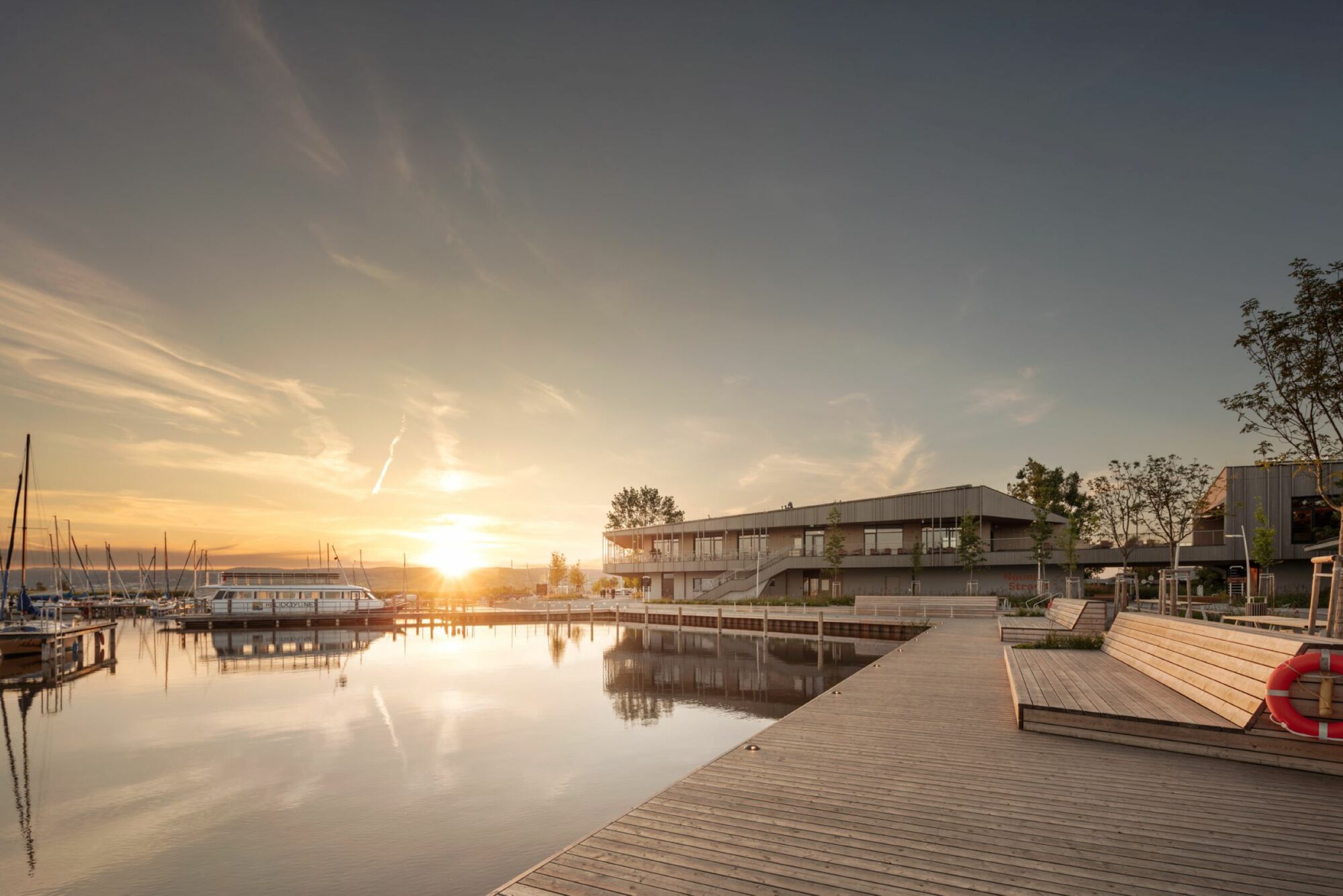 Eine Terrasse verbindet die beiden Gebäudeflügel am kleinen Yachthafen.