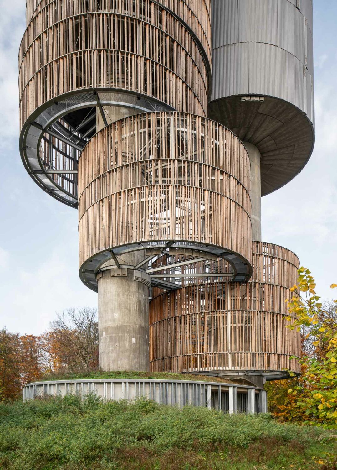Die Fassade des größeren Zylinders besteht aus vorgefertigten, gewellten Betonelementen, zwischen die auf unterschiedlichen Höhen Nistplätze für Schwalben eingefügt sind.
