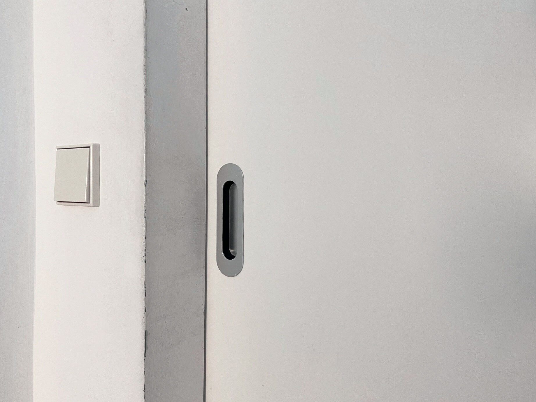 Eine Griffmuschel ist ein Tür- oder Möbelbeschlag, der eine vertiefte Mulde in der Oberfläche bildet. Im Bild: Griffmuschel aus Aluminium an Schiebtür