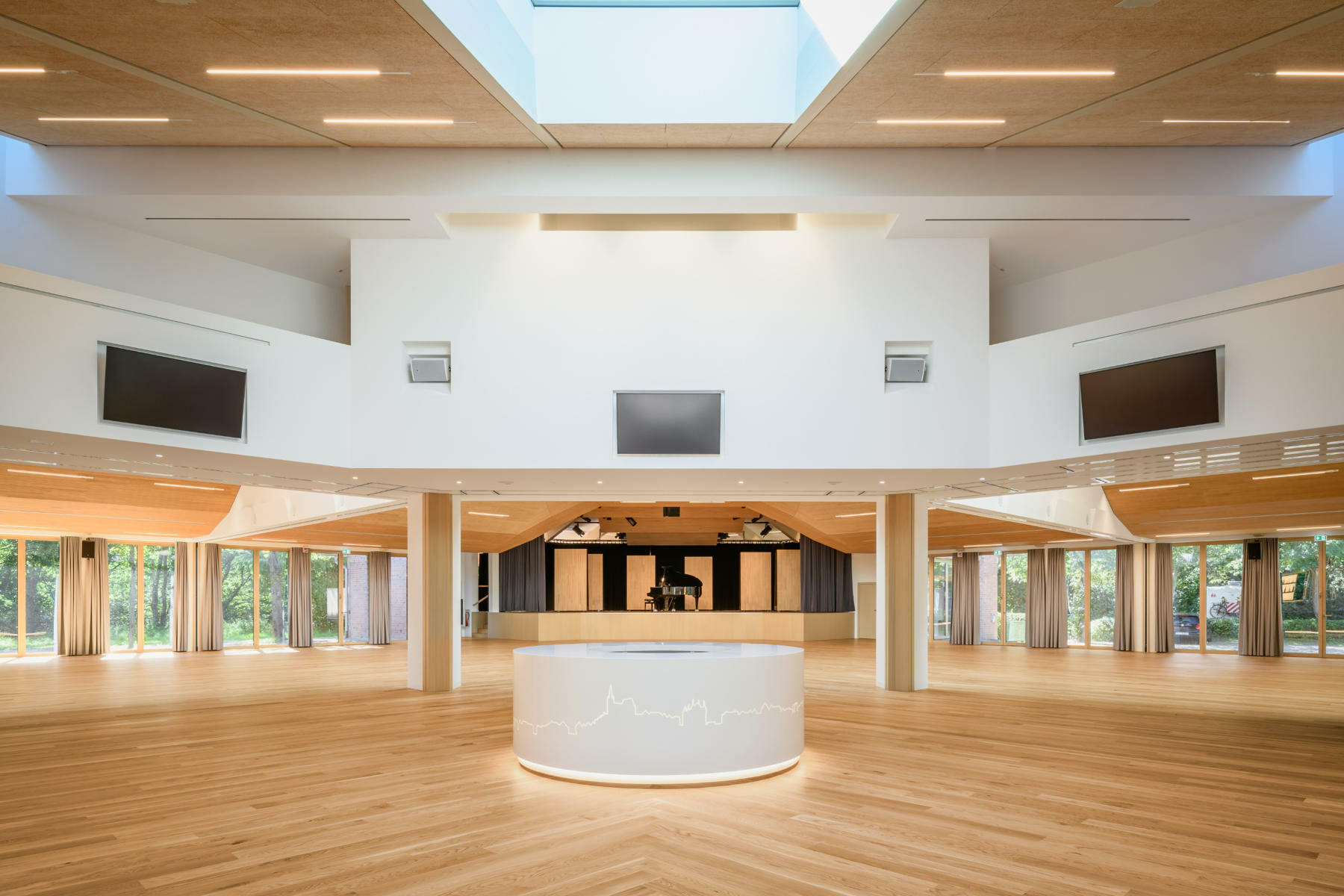Im Zentrum befindet sich ein offenes, lichtdurchflutetes Foyer mit polygonalem Grundriss, von dem aus die drei stützenfreien Säle erschlossen werden. 