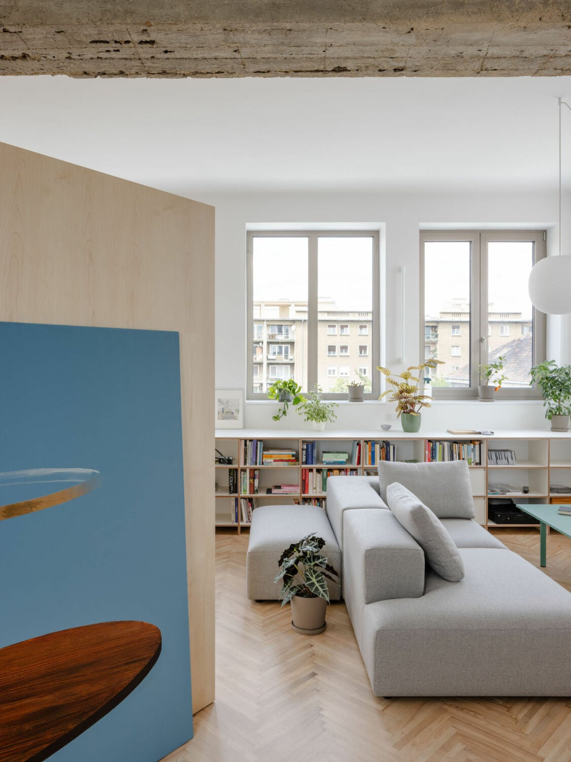Küche, Ess- und Wohnbereich orientieren sich zur Fassade mit großen Fensterflächen, die den Raum mit Tageslicht durchfluten.