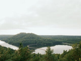 Die Pontonbrücke verbindet zwei Ufer einer Seenlandschaft im belgischen Nationalpark Hoge Kempen.