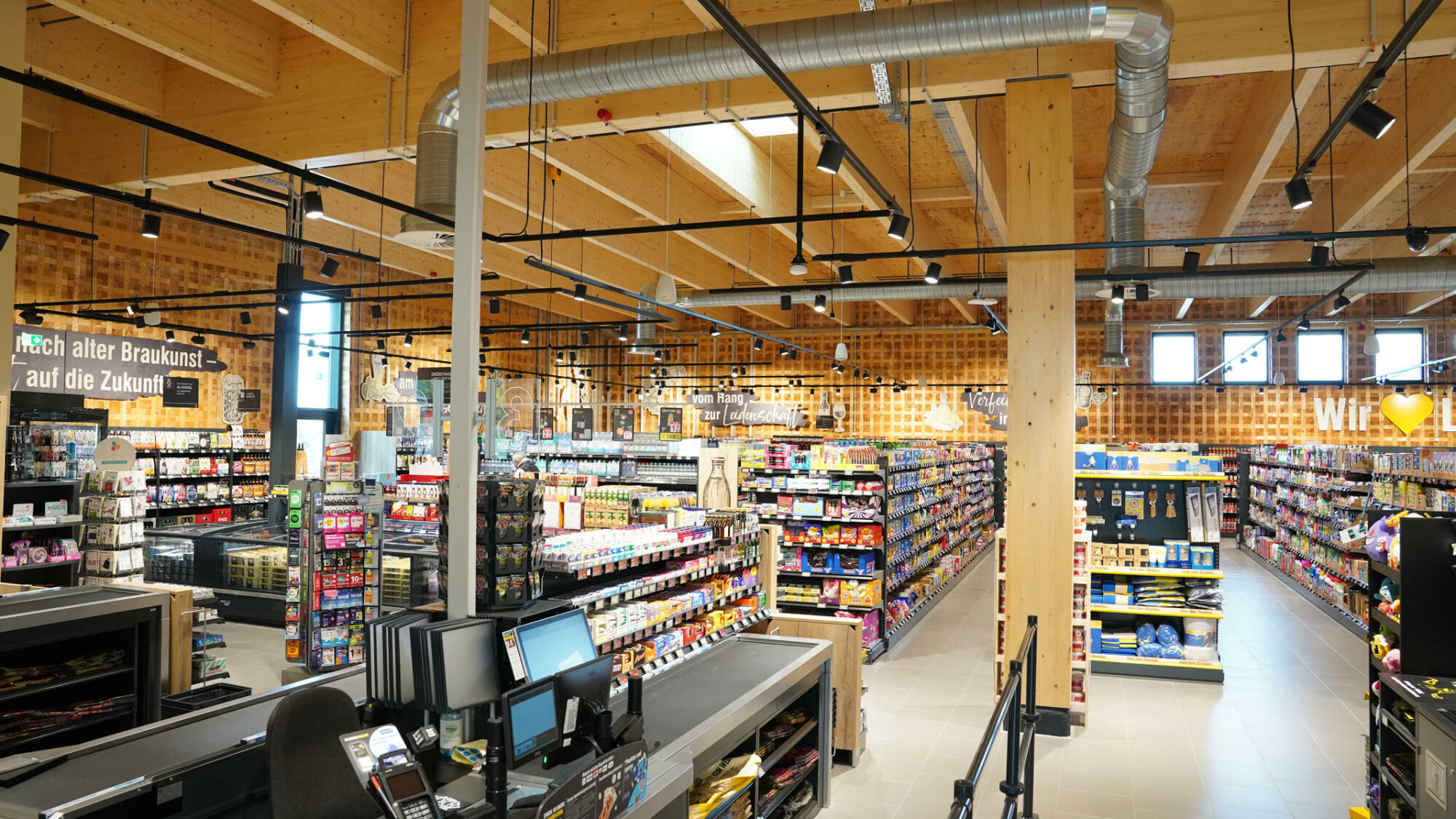 Das rund 1.100 Quadratmeter große Gebäude ist der erste Supermarkt in Deutschland, dessen tragende Konstruktion vollständig aus den mikro-modularen Holzbausteinen des Systems TriqBriq besteht. 