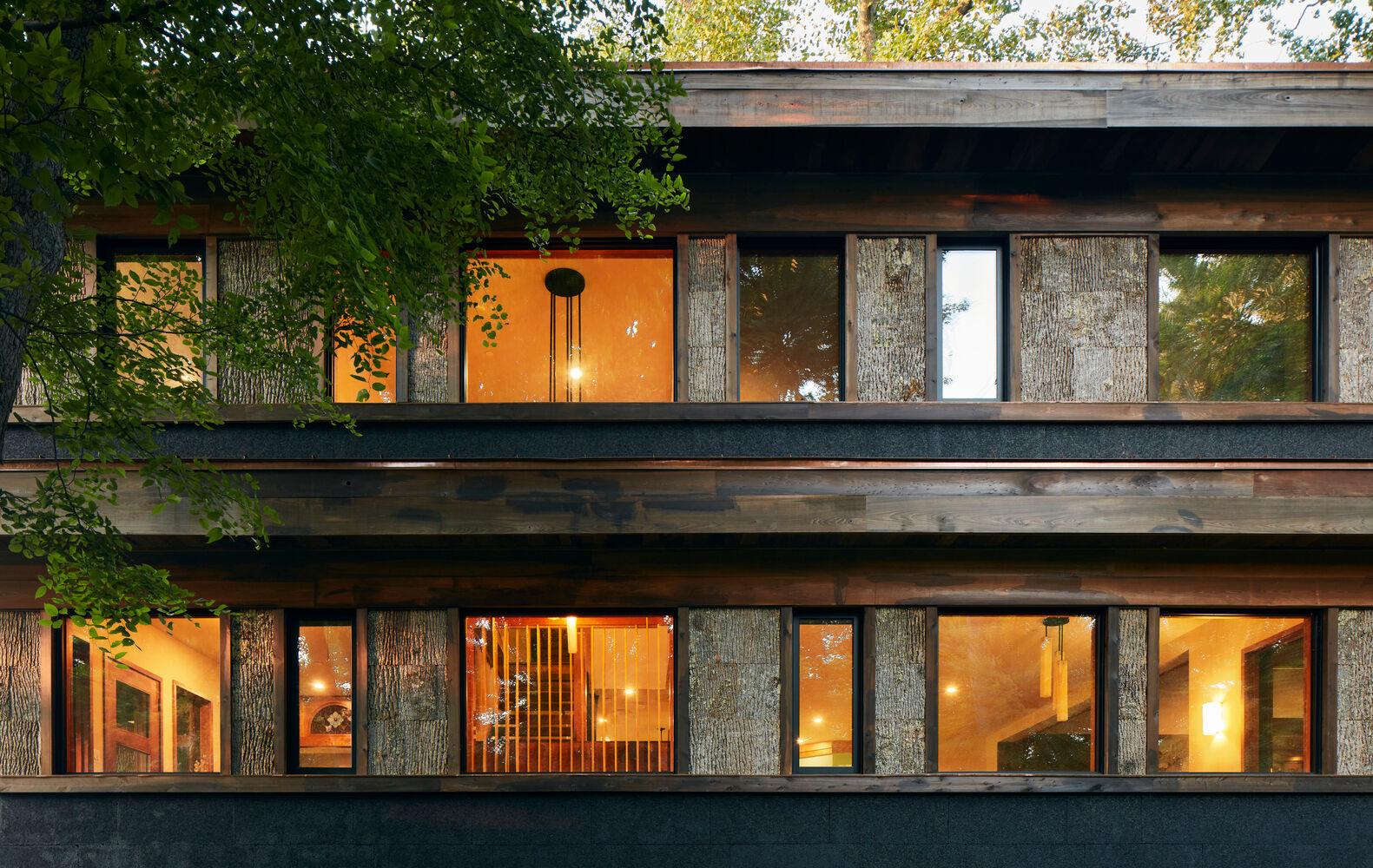 An der Fassade werden Kupfer, schwarz gebeiztes Kork, karbonisiertes Holz und Baumrinde kombiniert.