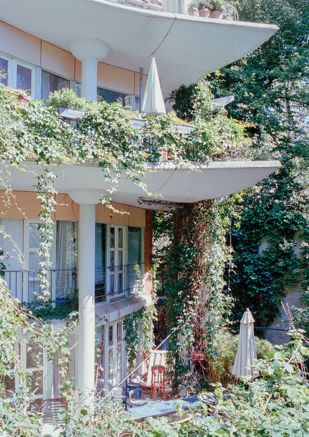 Wohnhäuser Fraenkelufer 26, 38 und 44: Pflanzen und auskragende Balkone verschatten im Sommer die Fassade.