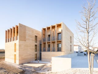 Das Büro Régis Roudil Architectes entwarf ein Mehrfamilienhaus mit acht Wohneinheiten, dessen Außenwände aus massiven Natursteinblöcken bestehen.