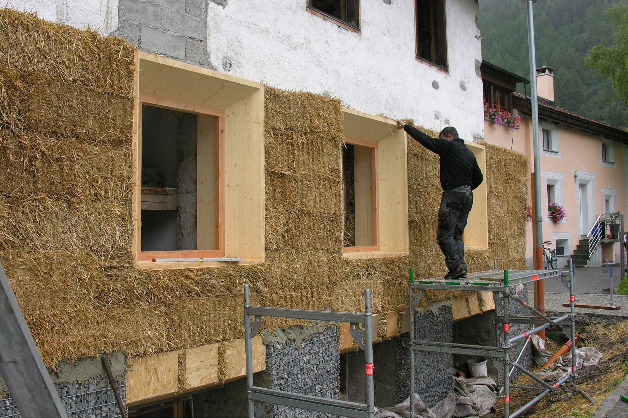 Vor die Bruchsteinwände wurden Strohballen aufeinandergeschichtet, fixiert mithilfe von Bretter und Führungsleisten.