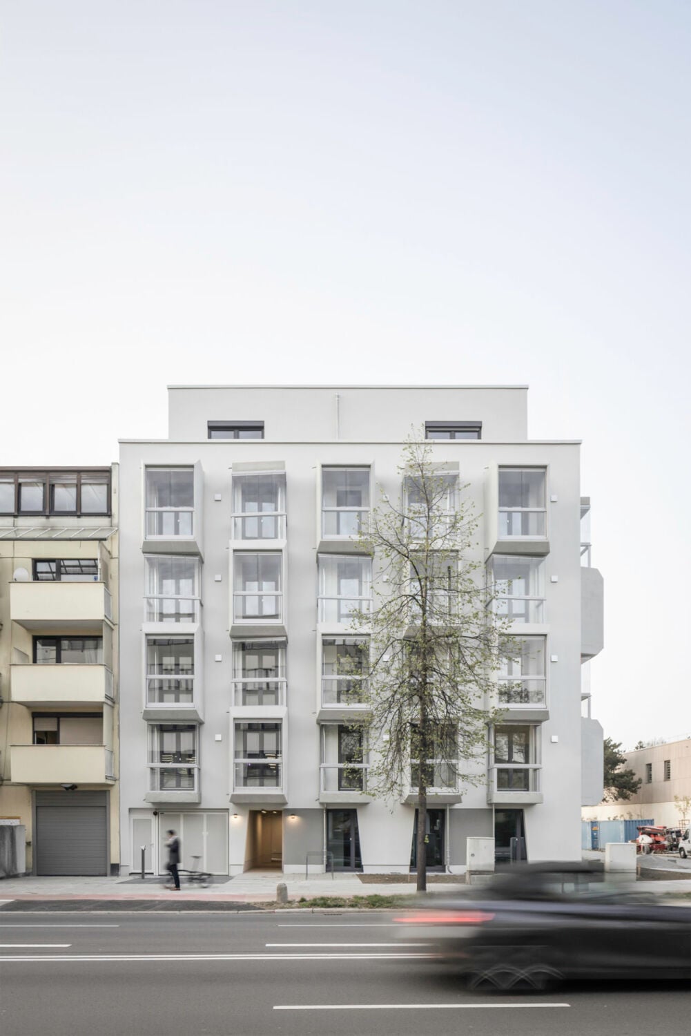 Zur Chiemgaustraße hin orientiert sich der sechsgeschossige Bau mit zurückversetztem Staffelgeschoss und Flachdach an der Traufkante der angrenzenden Bebauung.