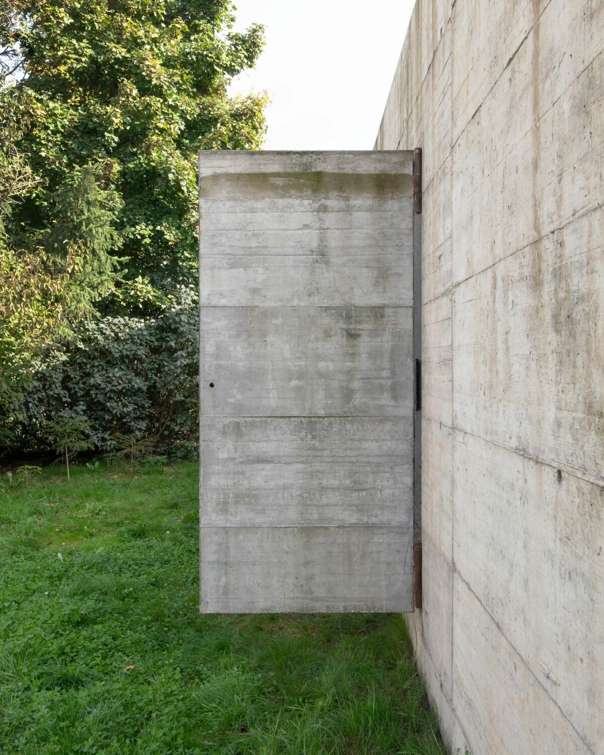 An der Westseite verschmilzt eine Betontüre mit der Fassade.