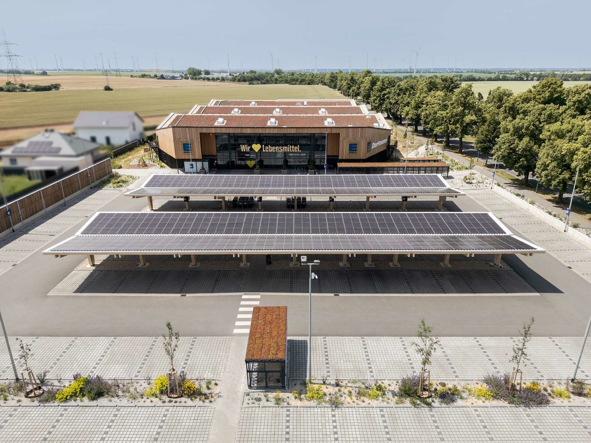 Auf dem Supermarktdach und auf den Unterständen der Parkplätze sind Photovoltaik-Module installiert.