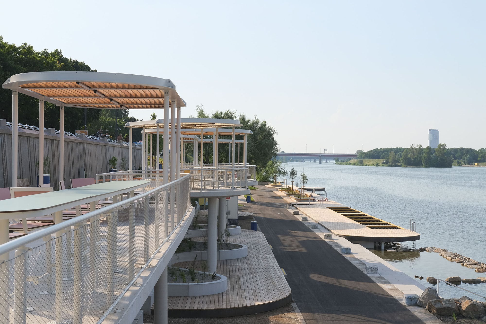 Eine Struktur aus Beton und weiß lackiertem Stahl fungiert als Überdachung und Terrasse.