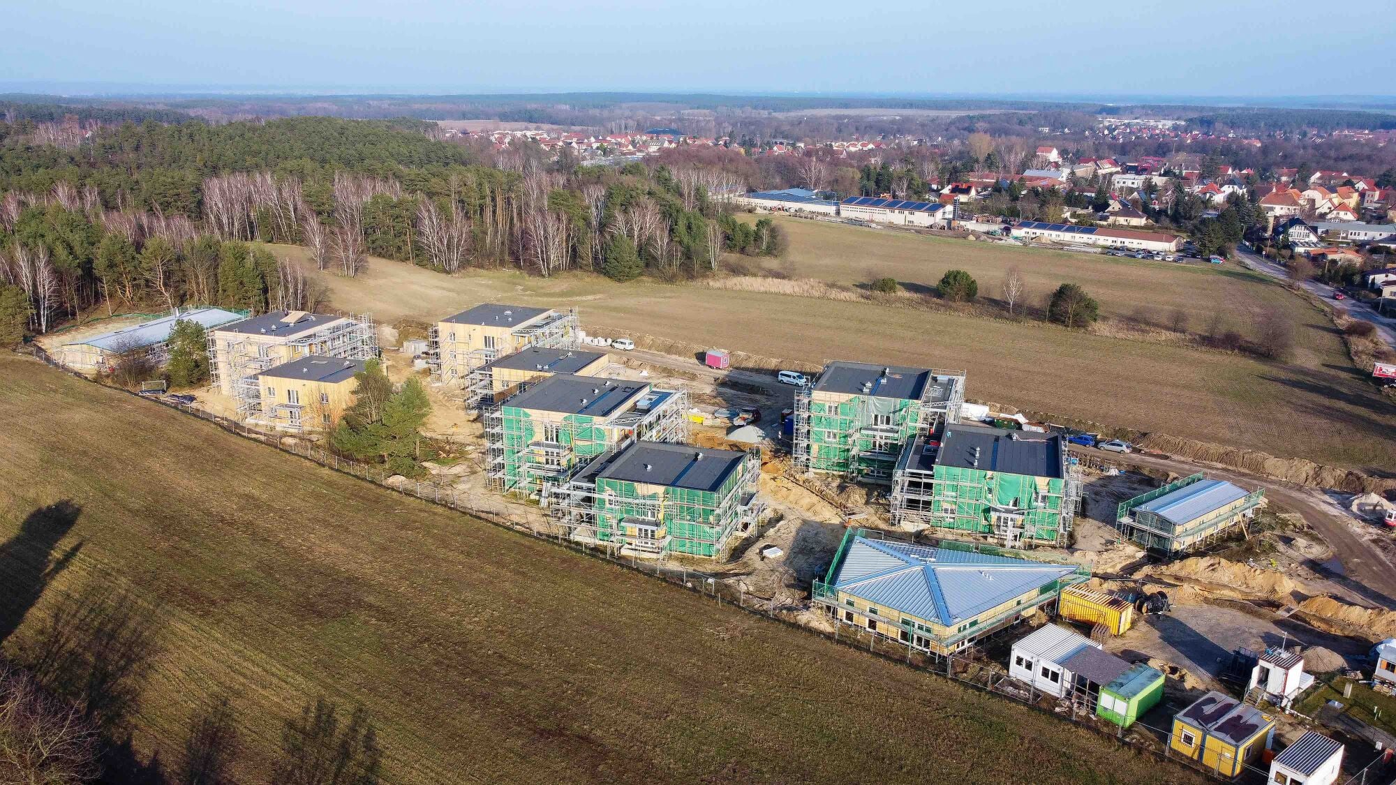 Auf dem lang gestreckten Grundstück am Ortsrand verteilen sich vier Wohngebäude und drei Gemeinschaftshäuser für rund hundert Menschen in verschiedenen Lebensphasen.