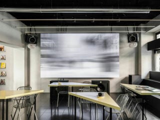 Nördlich des Mailänder Stadtzentrums hat das Büro Studio Wok im Sockel eines Altbaus die Section 80Bar gestaltet, die Weinbar, Kino und Bibliothek in einem Erdgeschoss vereint.