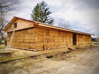 Die Diakonie Landgut Holzdorf erhielt 2024 ein temporäres, vom Büro Z-Architektur geplantes Schulungsgebäude, dessen Außenwände aus lasttragenden Strohballen bestehen.