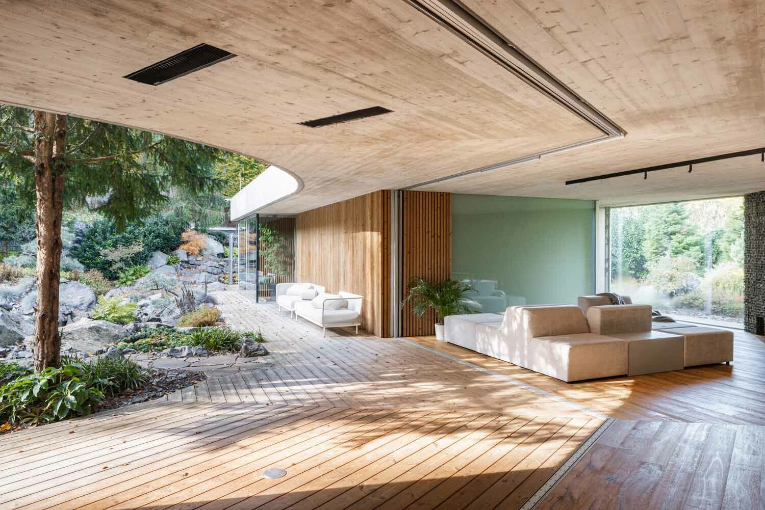 Die großflächigen, vollständig zu öffnenden Verglasungen lassen die Grenze zwischen Innen- und Außenraum verschwinden und verbinden das Haus nahtlos mit dem Garten.