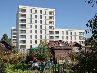 Am Rand des neuen Quartiers Les Sciers platzierte die ARGE Perraudin Archiplein Consortium zwei annähernd gleiche Sozialwohnungsbauten mit Blick über Schrebergärten und Felder.