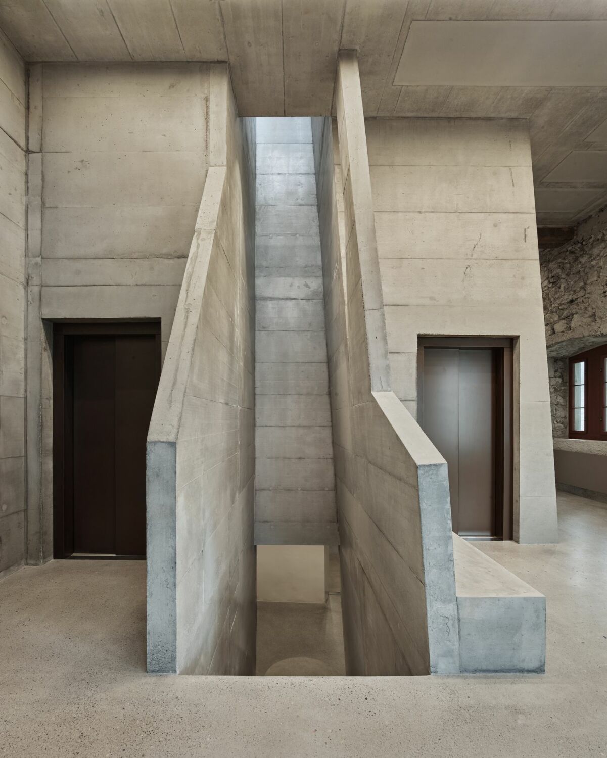Im Osten entstanden zwei Aufzüge für Waren und Personen sowie eine skulpturale Treppe, die sich in unregelmäßigem Verlauf nach oben windet.