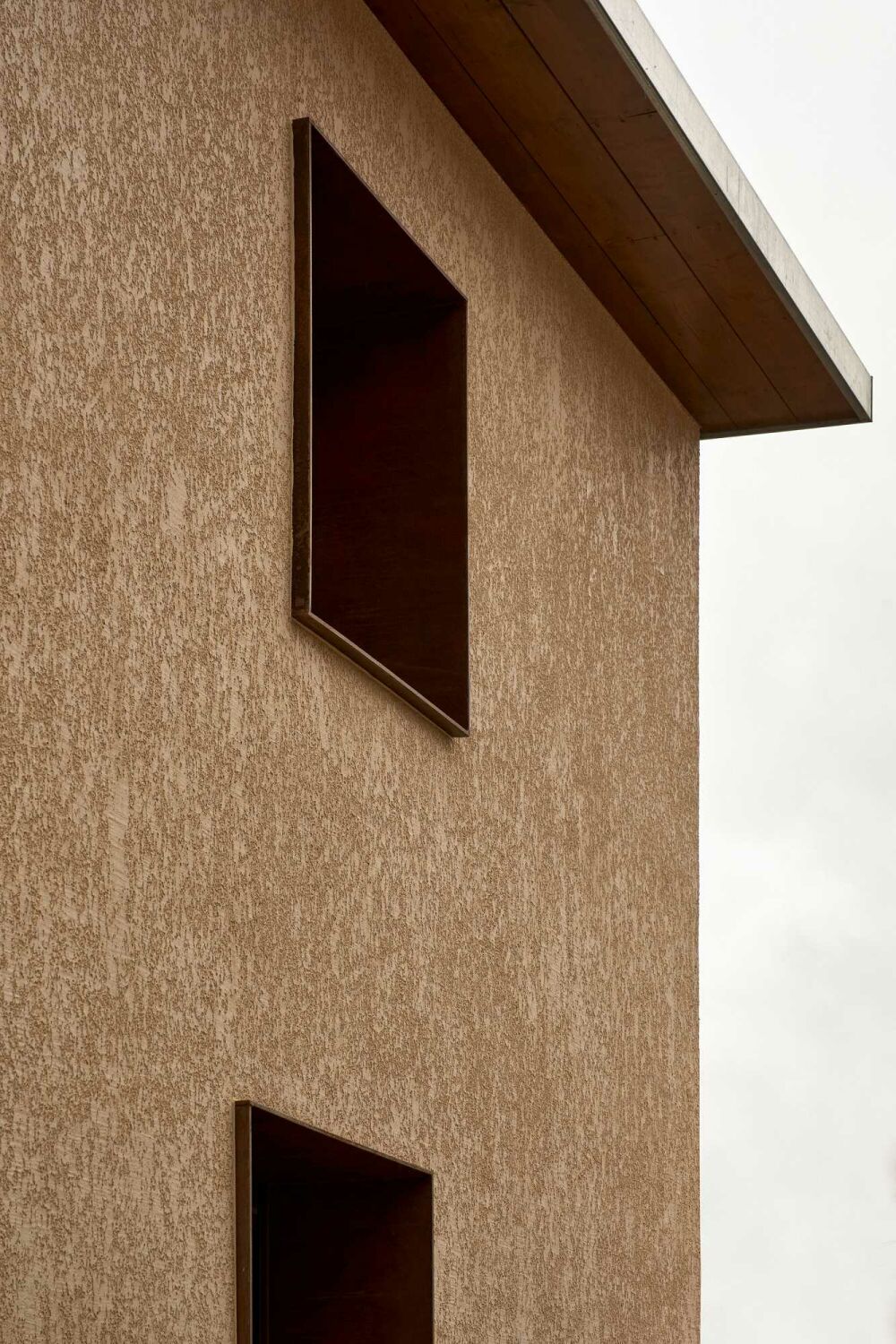Die Fassade ist neu verputzt mit hellbraunen Kalk-Sand-Mörtel.