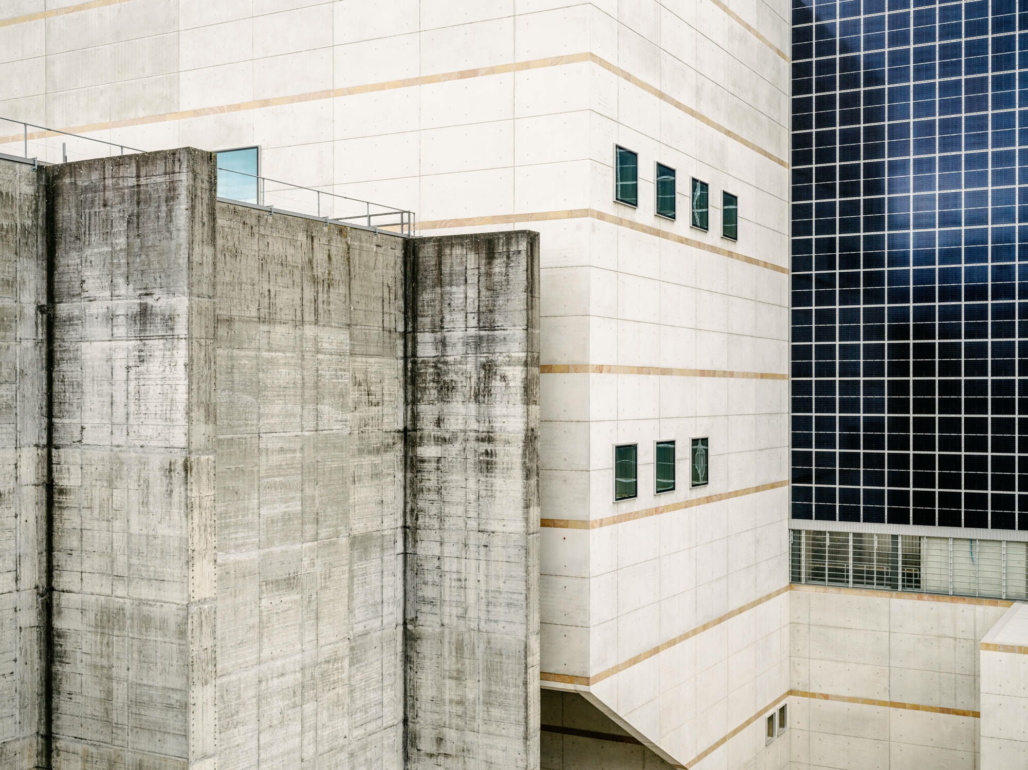 Die Sichtbetonfassade wird von Bändern aus Jurakalkstein gegliedert.