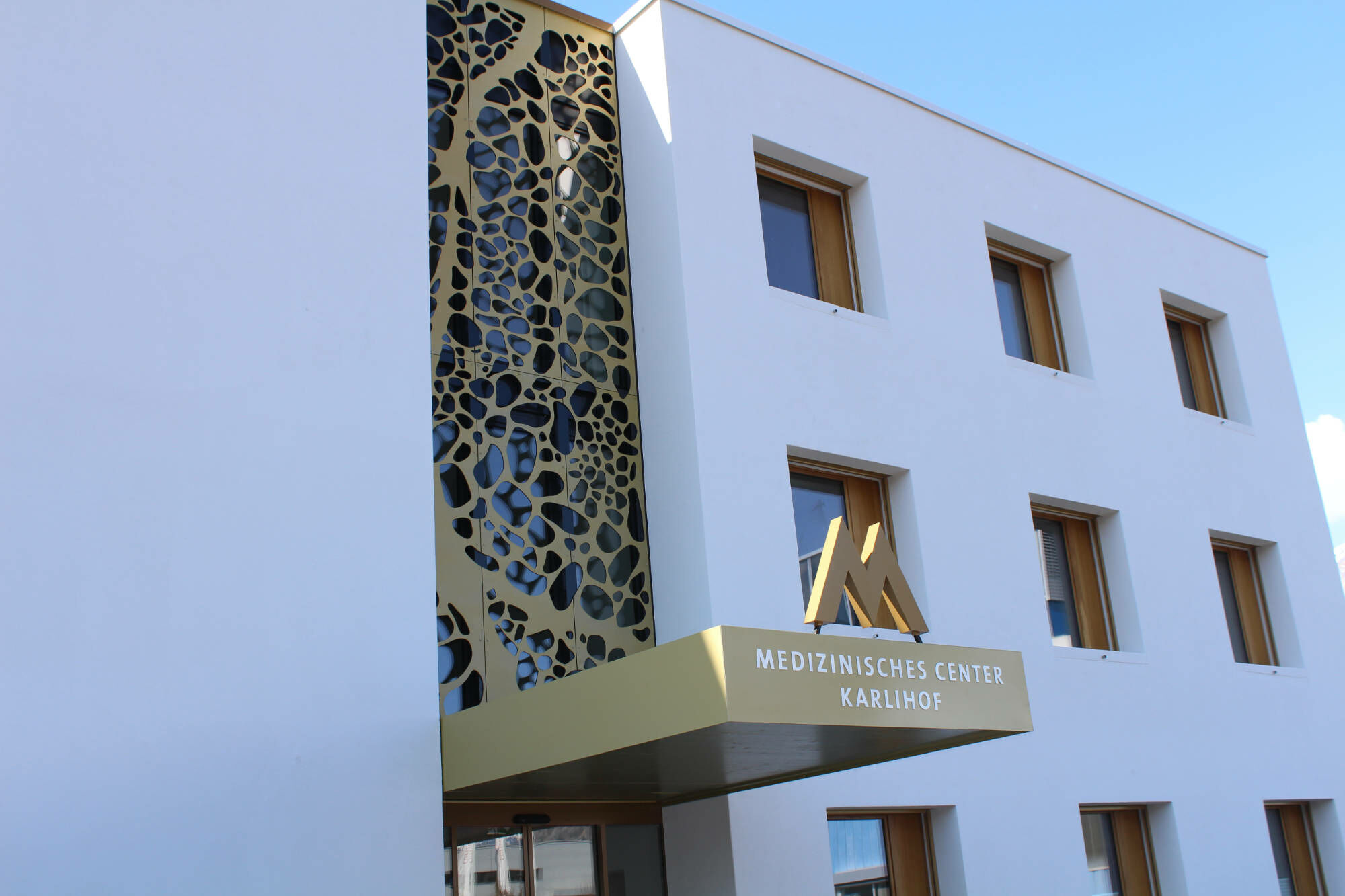 Die organisch durchbrochene Fassade filtert Sonnenlicht, mindert Blendung und erzeugt ein lebendiges Schattenspiel im Inneren.