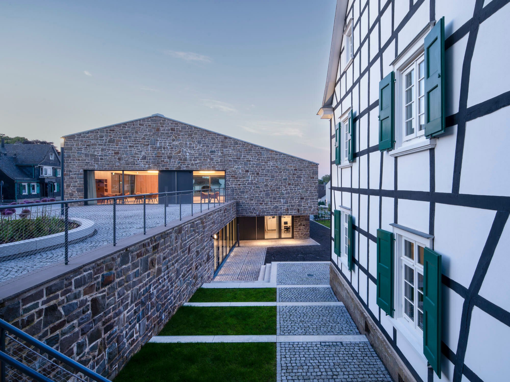 Das neue Gemeindehaus von Kastner Pichler Schorn Architekten bildet mit dem bestehenden großen Fachwerkbau des Pfarrhauses und dem denkmalgeschützten Gotteshaus aus Bruchstein eine neue Mitte.